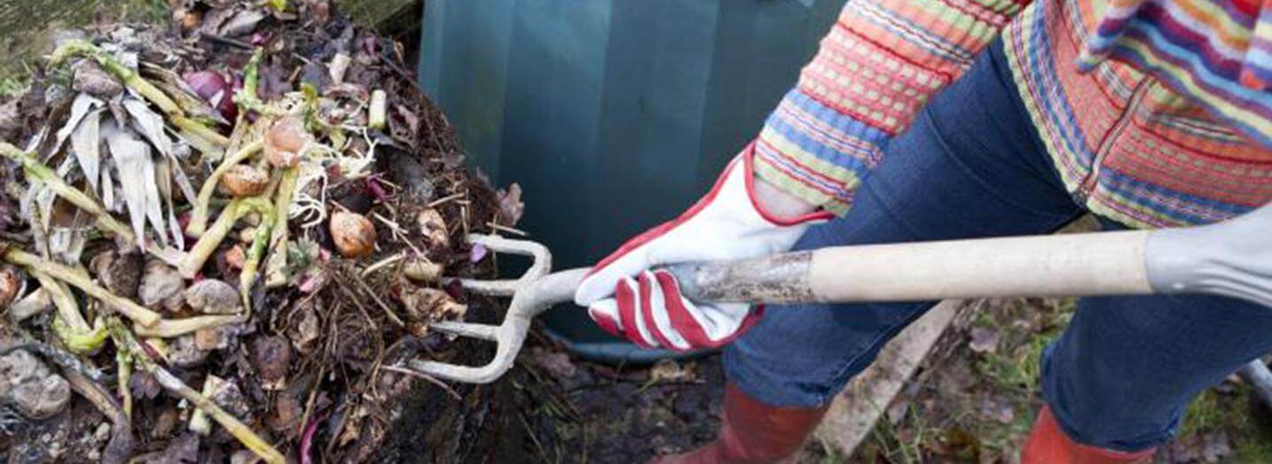 a person shovelling compost