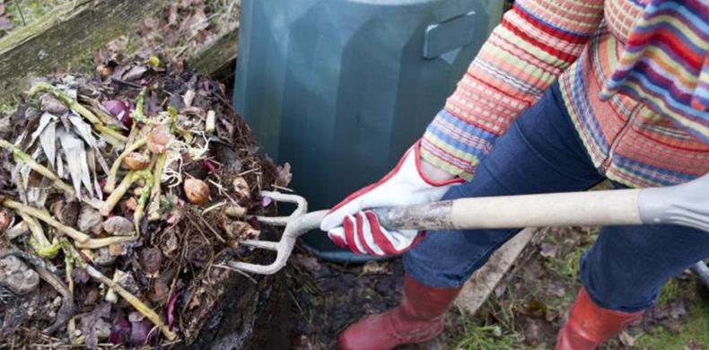a person shovelling compost